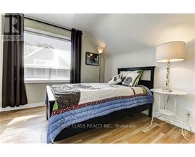 A bedroom with a bed, nightstand, and window.