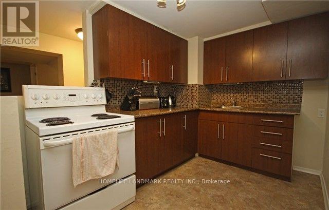 A kitchen with a white stove top oven and brown cabinets.