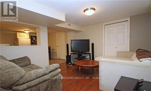 A living room with a couch, a television, and a speaker.