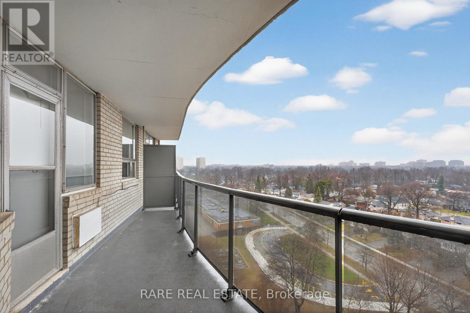 A balcony with a view of a park and buildings.
