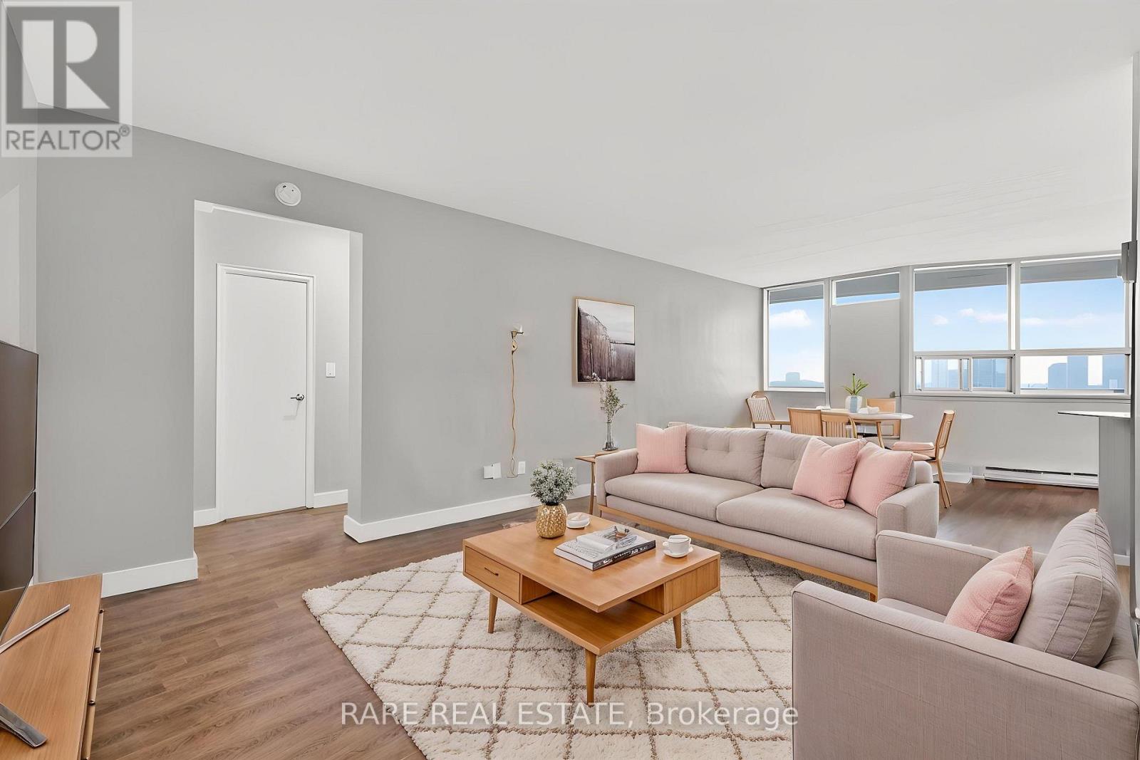 A living room with a couch, coffee table, and a painting on the wall.