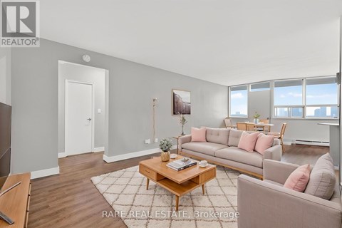 A living room with a couch, coffee table, and a painting on the wall.