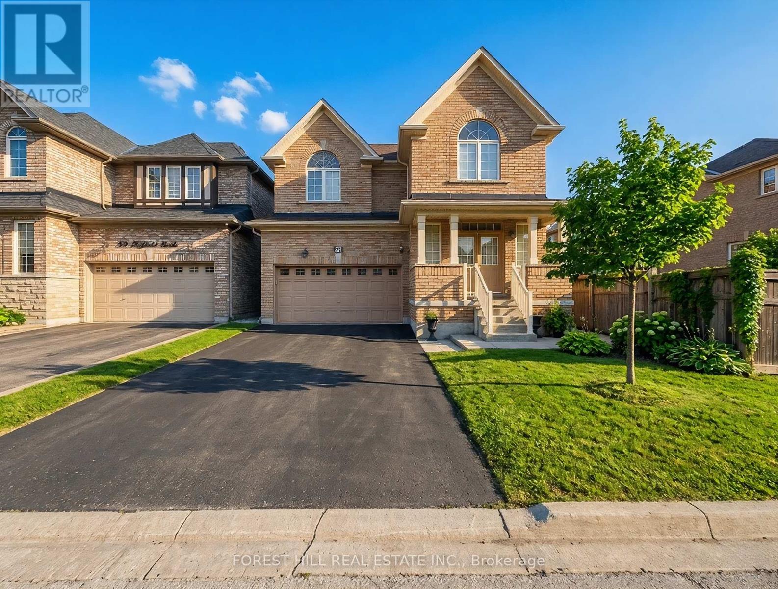 A large, well-maintained house with a driveway in front.