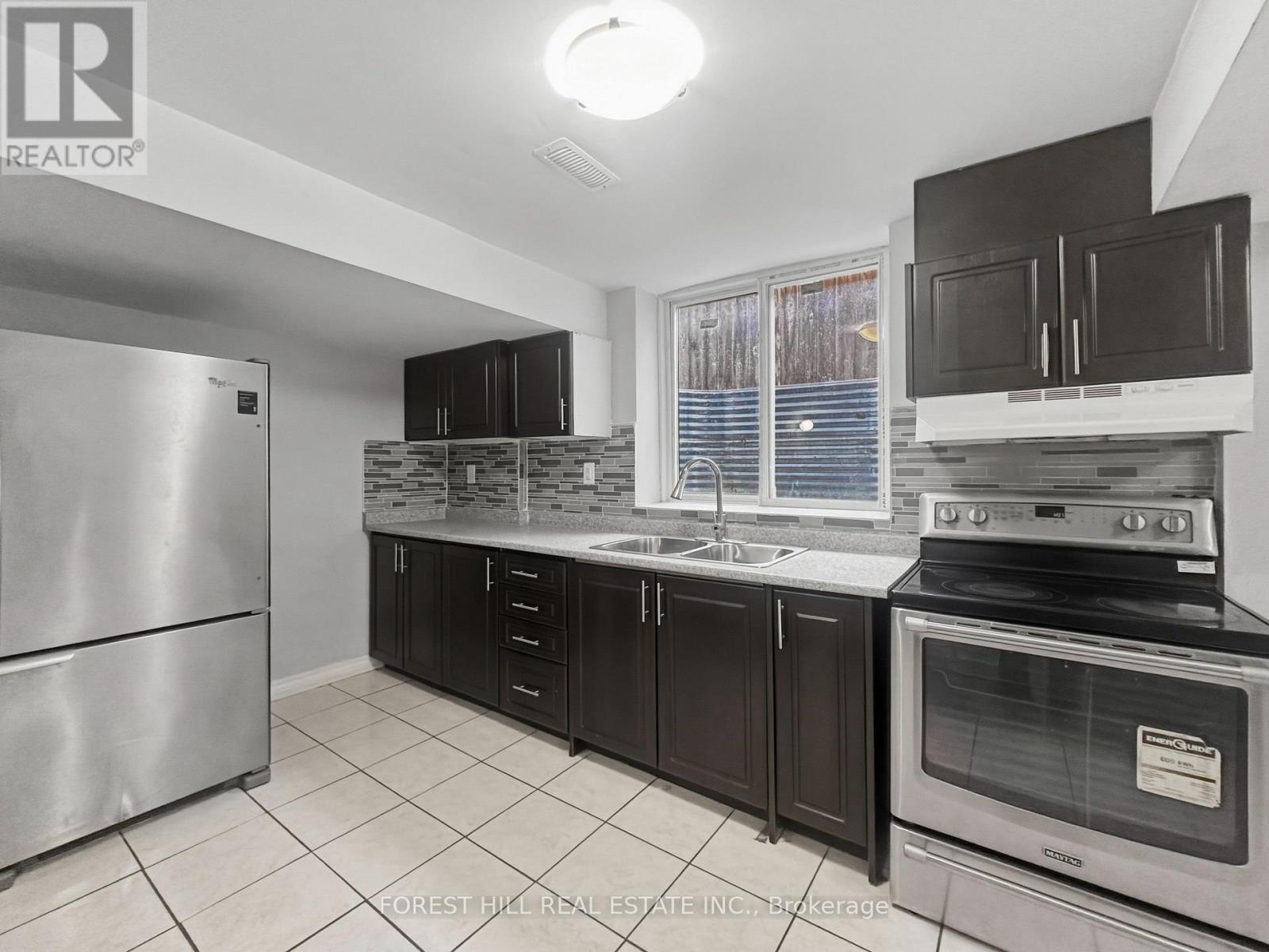 A kitchen with a refrigerator, oven, and microwave.