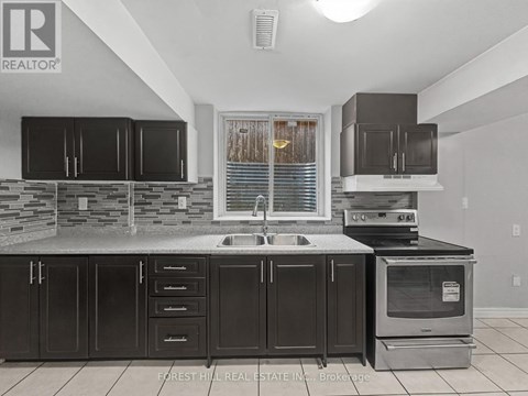 A kitchen with black cabinets and a stone counter.