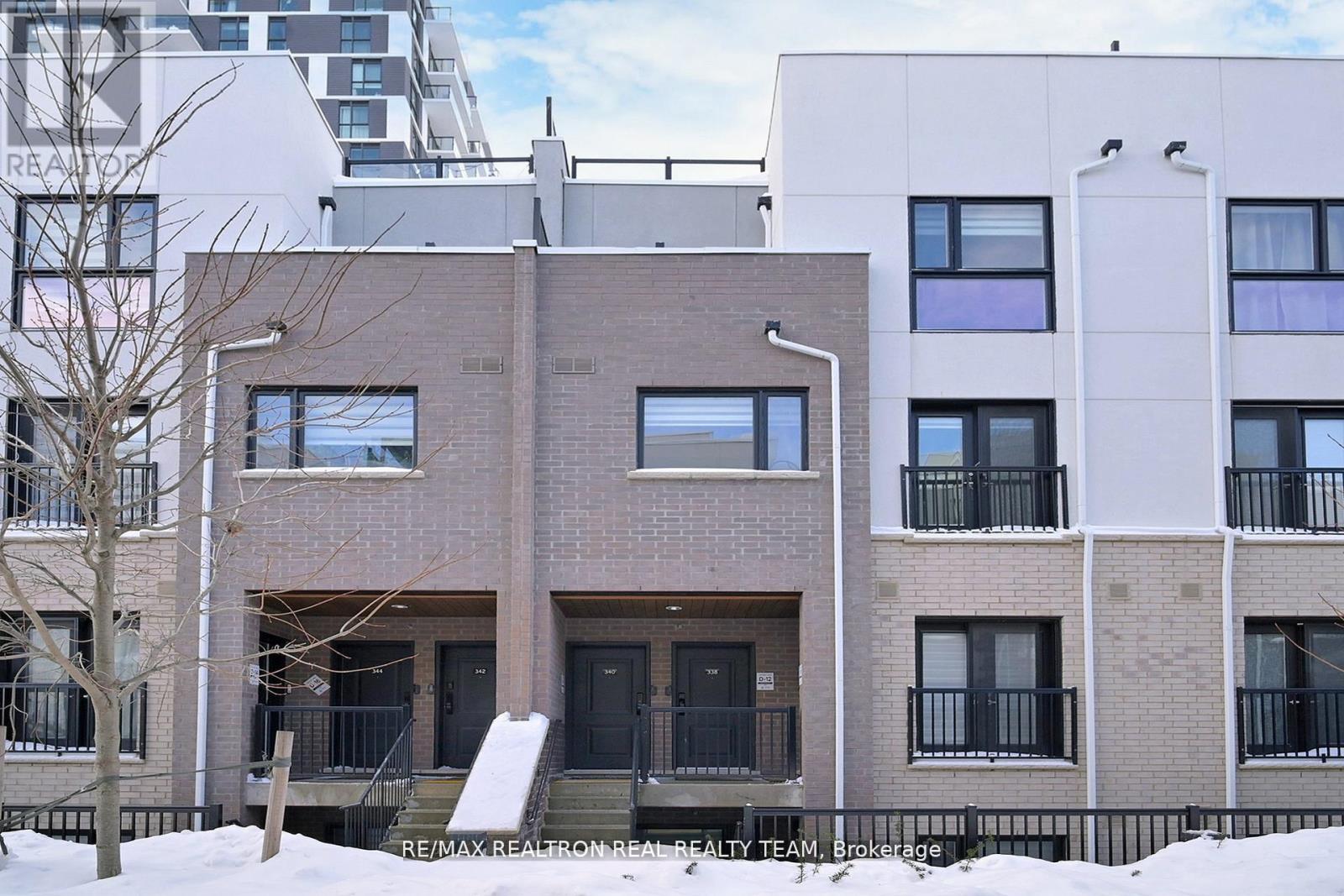 A building with a black door and a balcony with a railing.
