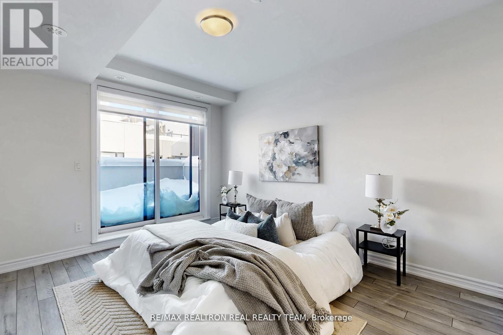 A bedroom with a large bed and a painting on the wall.