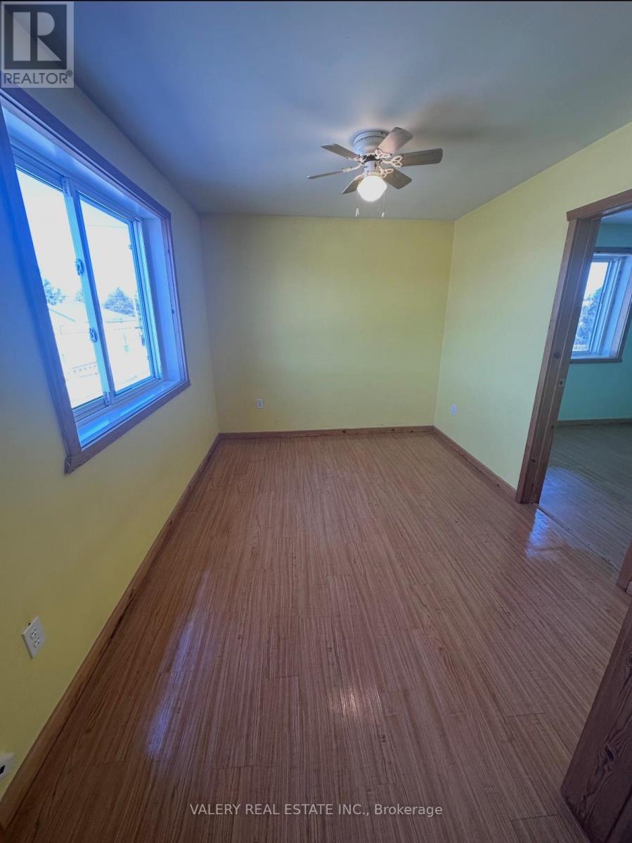 A room with a ceiling fan and wooden flooring.