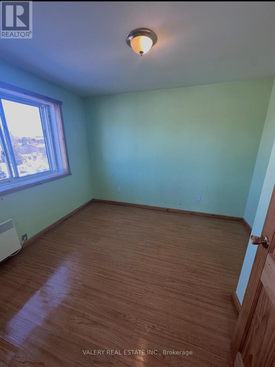 A room with wood flooring and a window.