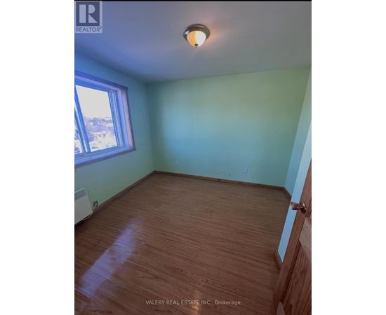 A room with wood flooring and a window.