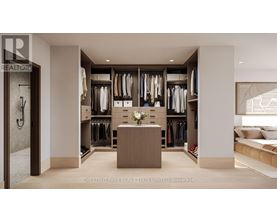 A well-lit, spacious walk-in closet with a bench and a large mirror.