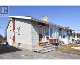 A house with a red and white exterior is for sale through Tru Realty Brokerage.