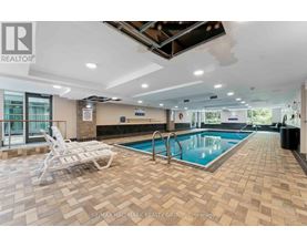 A large indoor swimming pool with a tiled floor and a sunken seating area.
