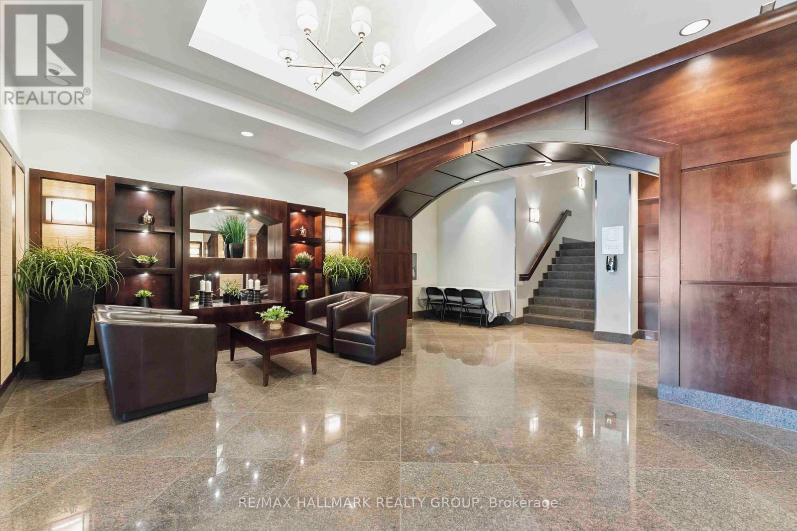 A spacious lobby with a staircase and a reception desk.