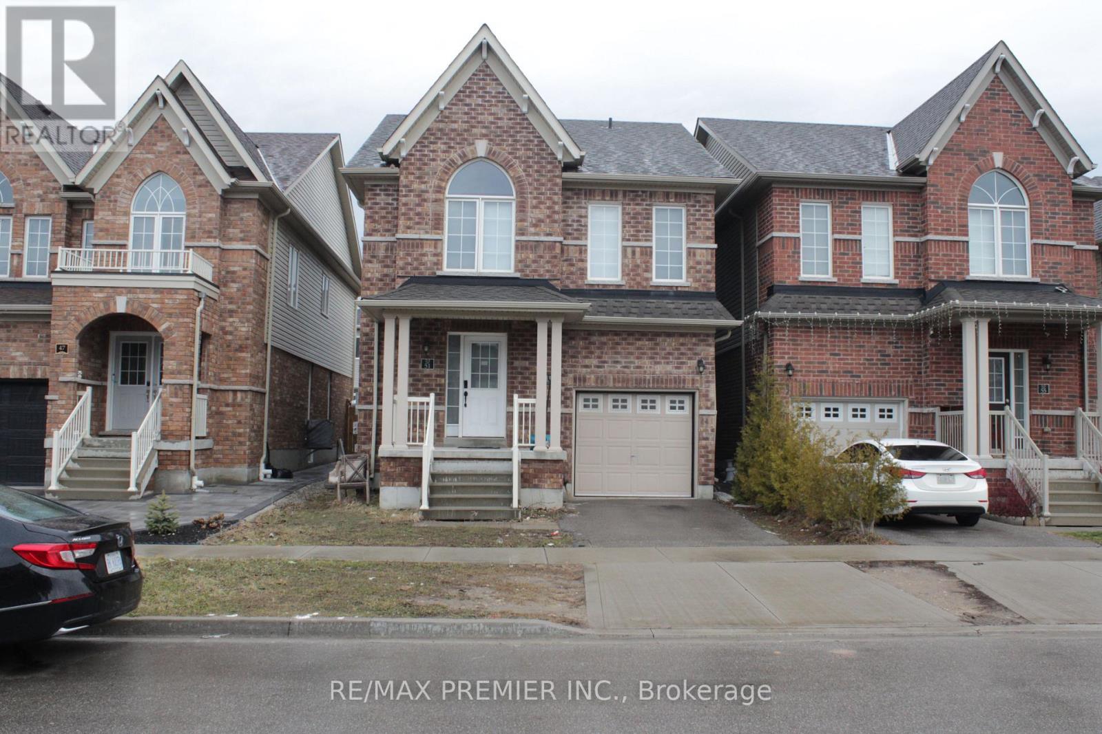 A large brick house with a car parked in front.