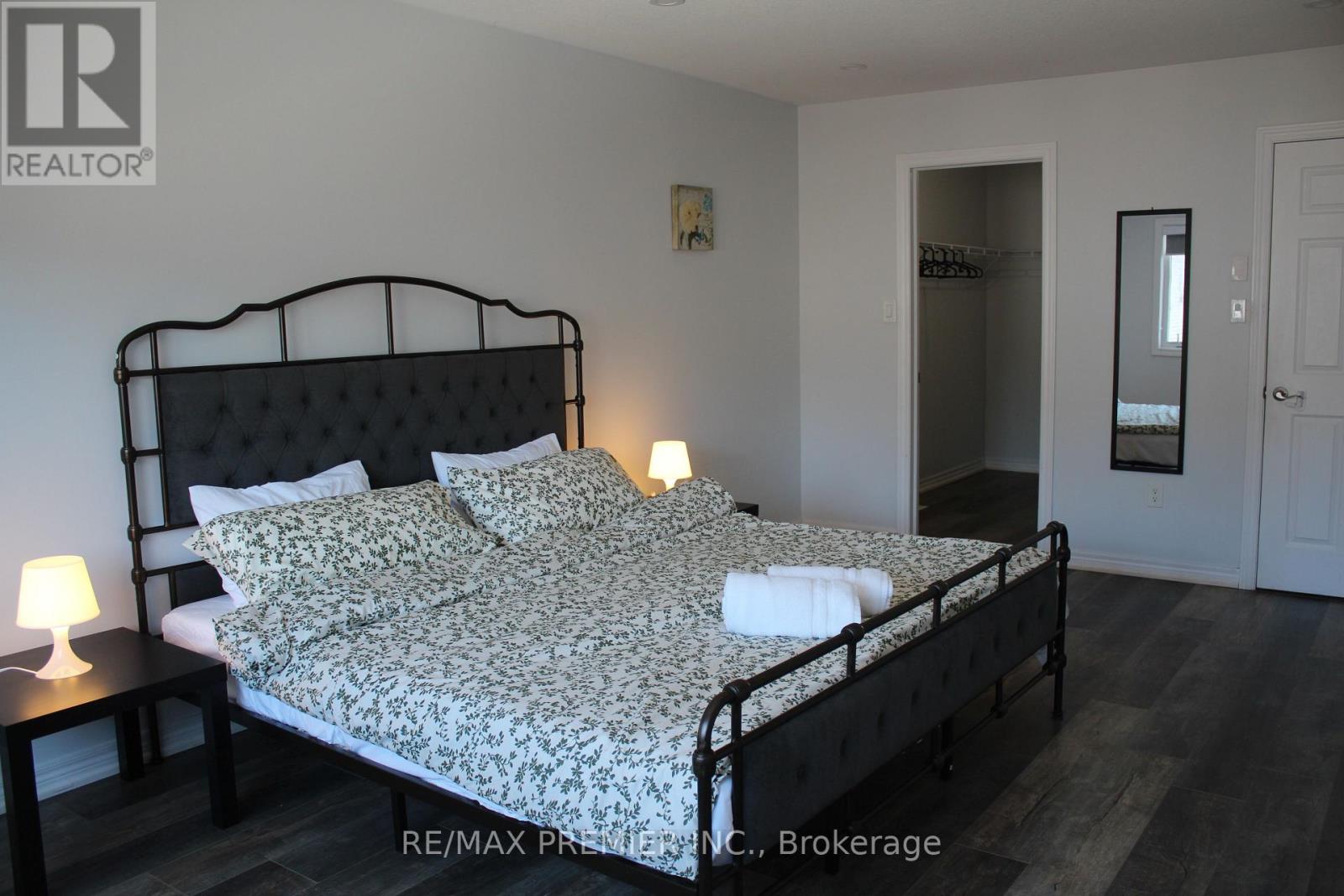 A bedroom with a bed, nightstand, and lamp.