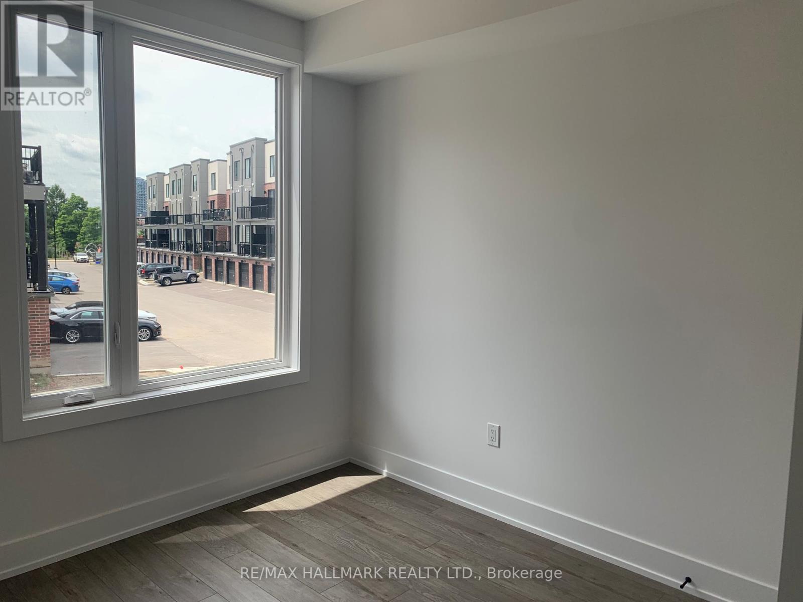 A room with a large window overlooking a parking lot.