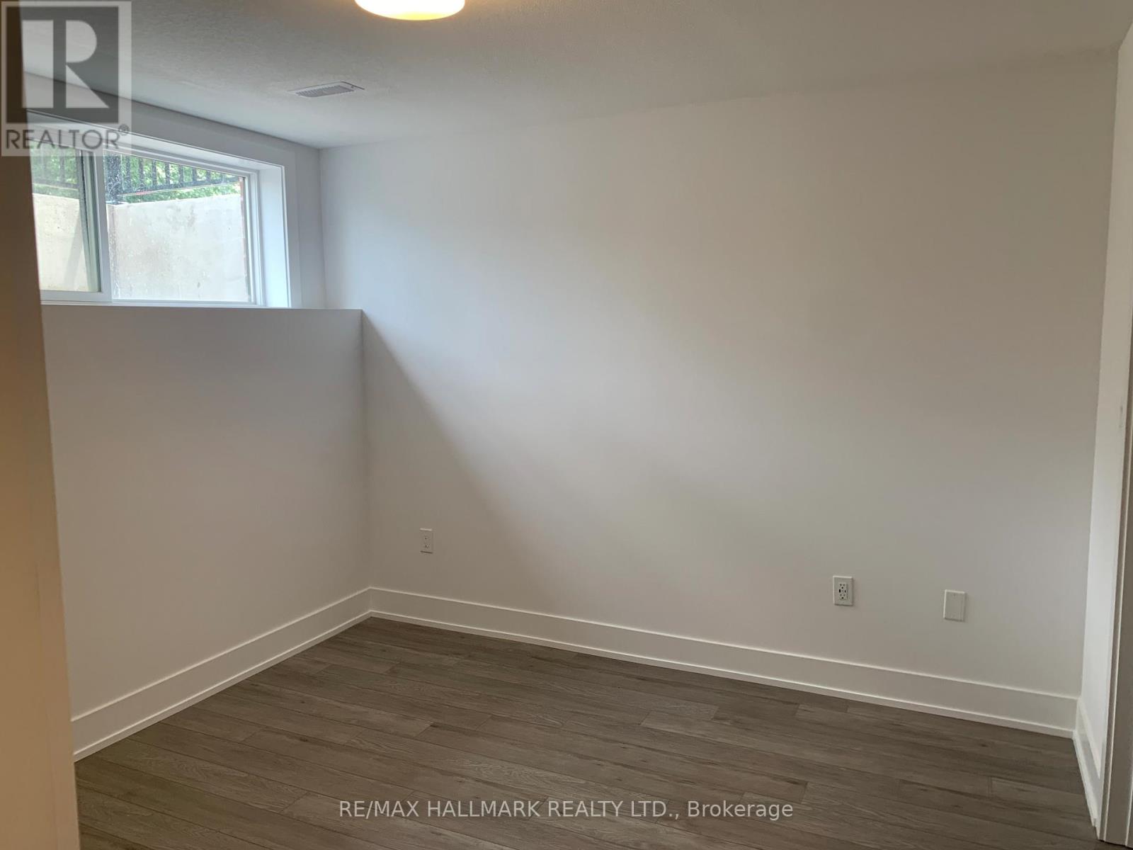 A room with a window and wooden flooring.