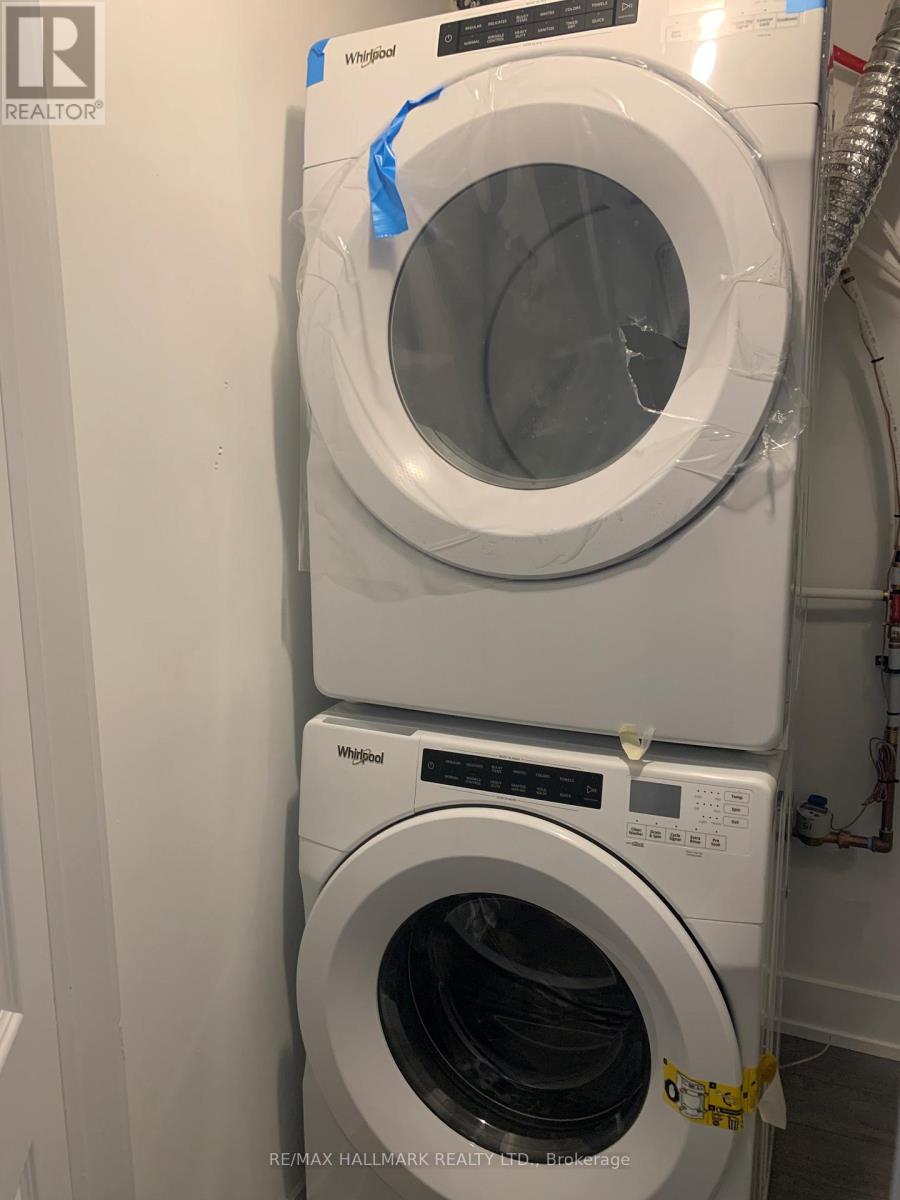 A white Whirlpool washing machine is stacked on top of another in a laundry room.