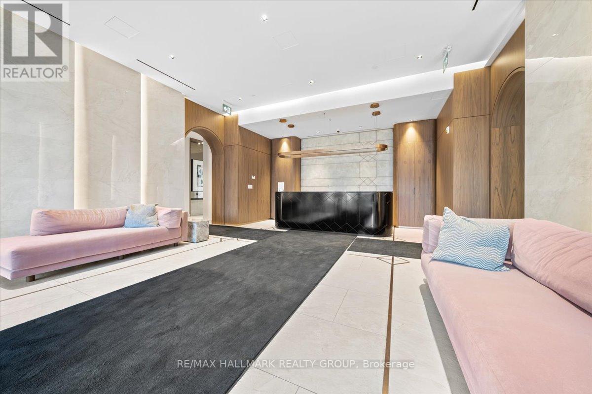 A living room with a pink couch and a black rug.
