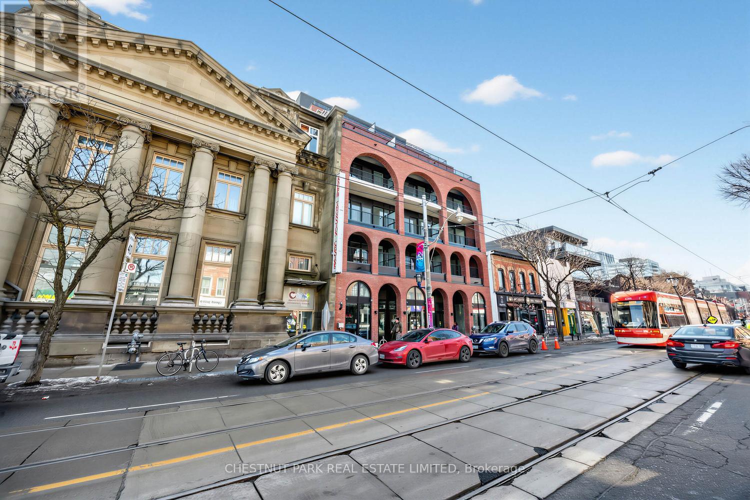 A street view with cars, a bus, and a tram.