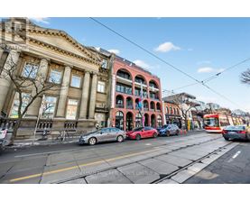 A street view with cars, a bus, and a tram.