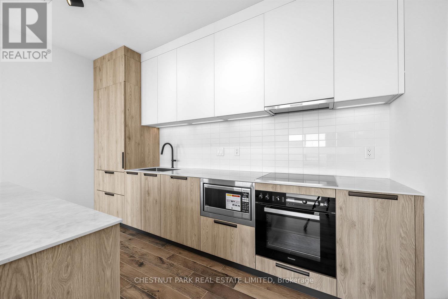 A modern kitchen with wooden cabinets and a marble countertop.