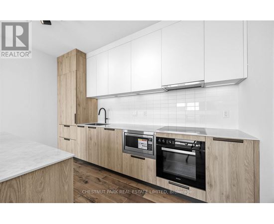 A modern kitchen with wooden cabinets and a marble countertop.