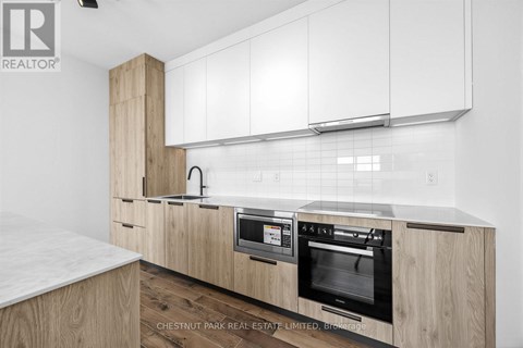 A modern kitchen with wooden cabinets and a marble countertop.