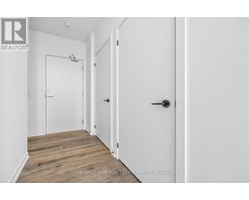 A hallway with a door on the right and a white door on the left.