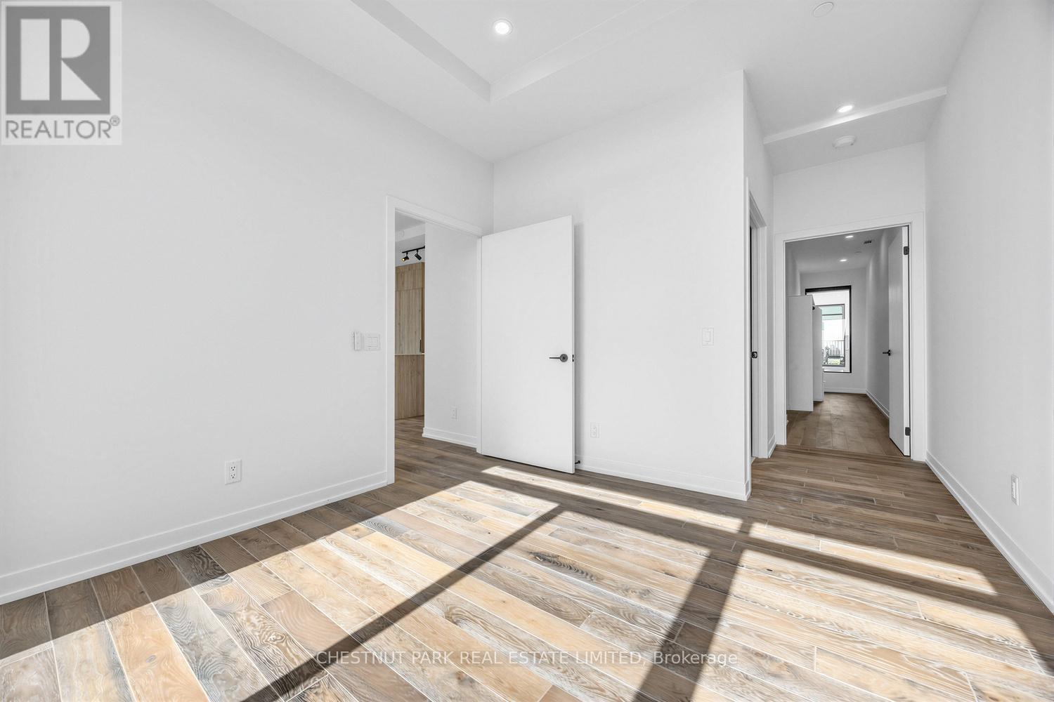 A spacious room with a wooden floor and white walls.