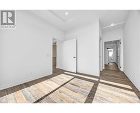 A spacious room with a wooden floor and white walls.