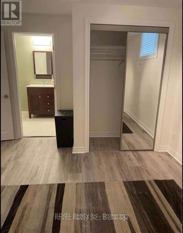 A hallway with a mirror and a trash can.