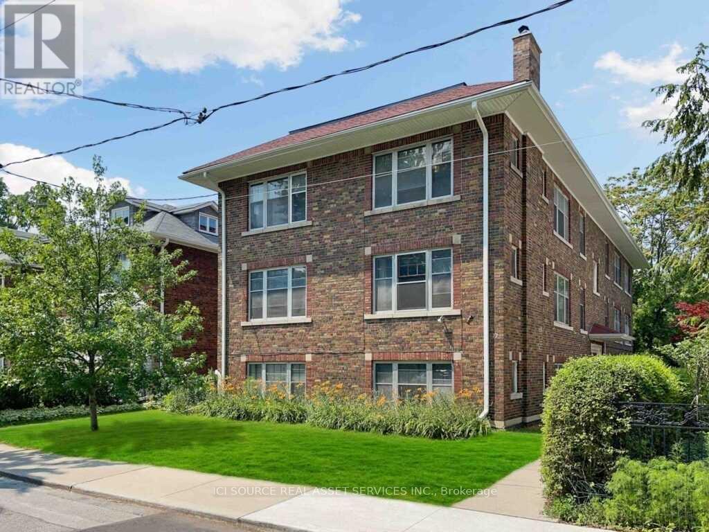 A brick house with a green lawn in front.
