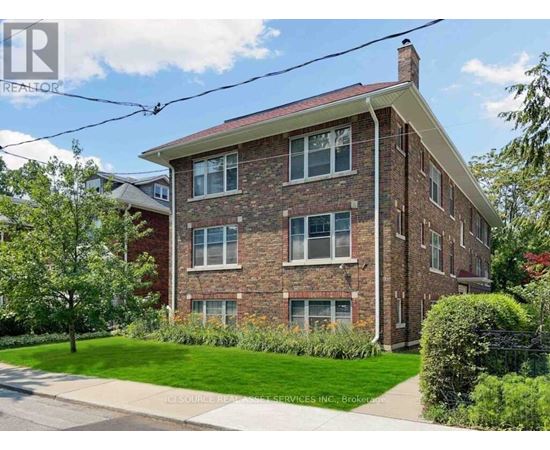 A brick house with a green lawn in front.