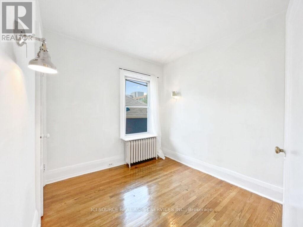 A room with a window showing a view of a building outside.