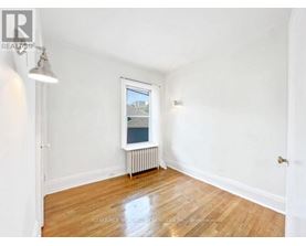 A room with a window showing a view of a building outside.