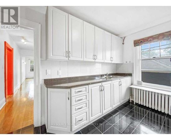 A kitchen with white cabinets and a black countertop.