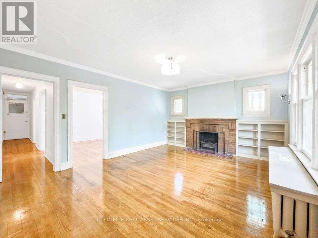 A spacious living room with a fireplace and hardwood floors.