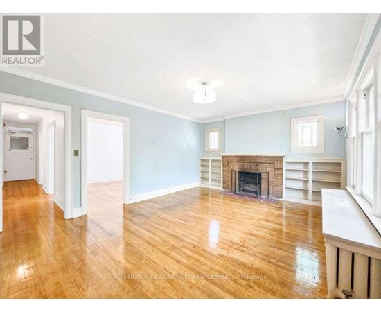 A spacious living room with a fireplace and hardwood floors.