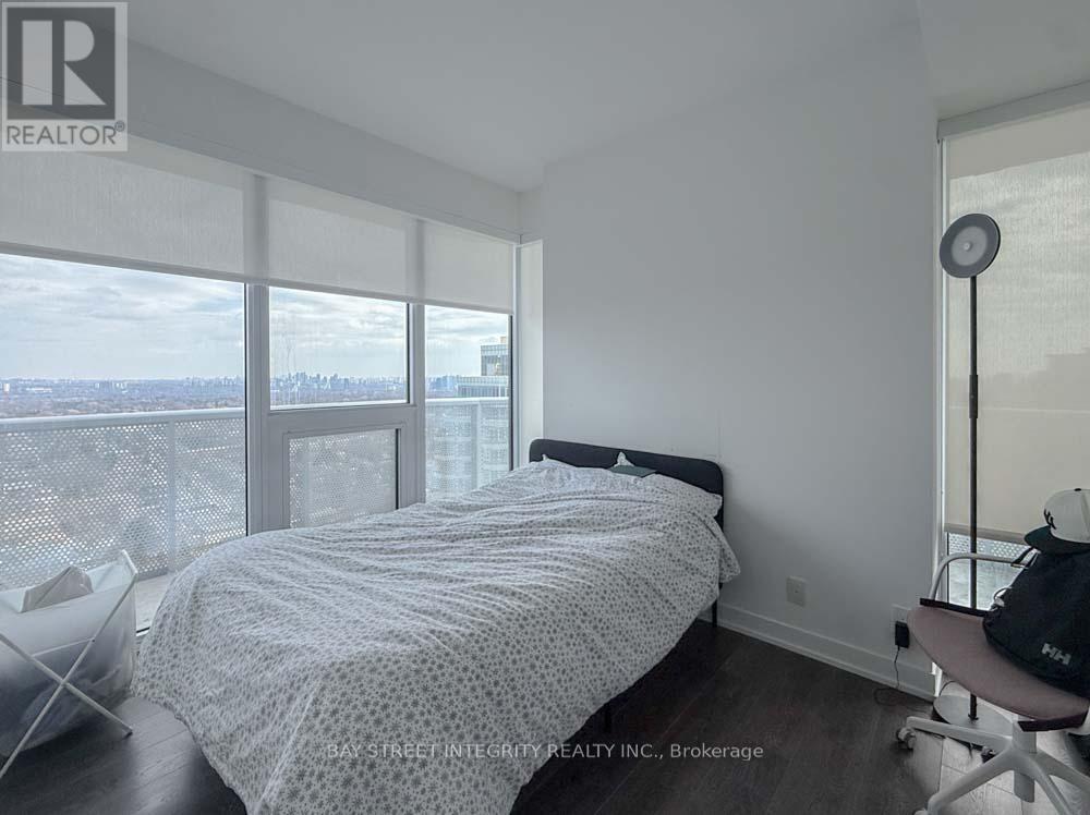 A bedroom with a large bed and a view of the city.