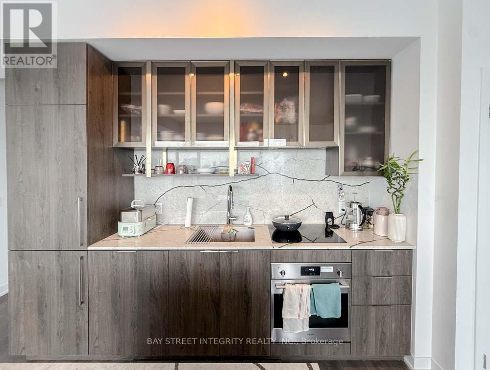 A modern kitchen with a stainless steel oven and wooden cabinets.
