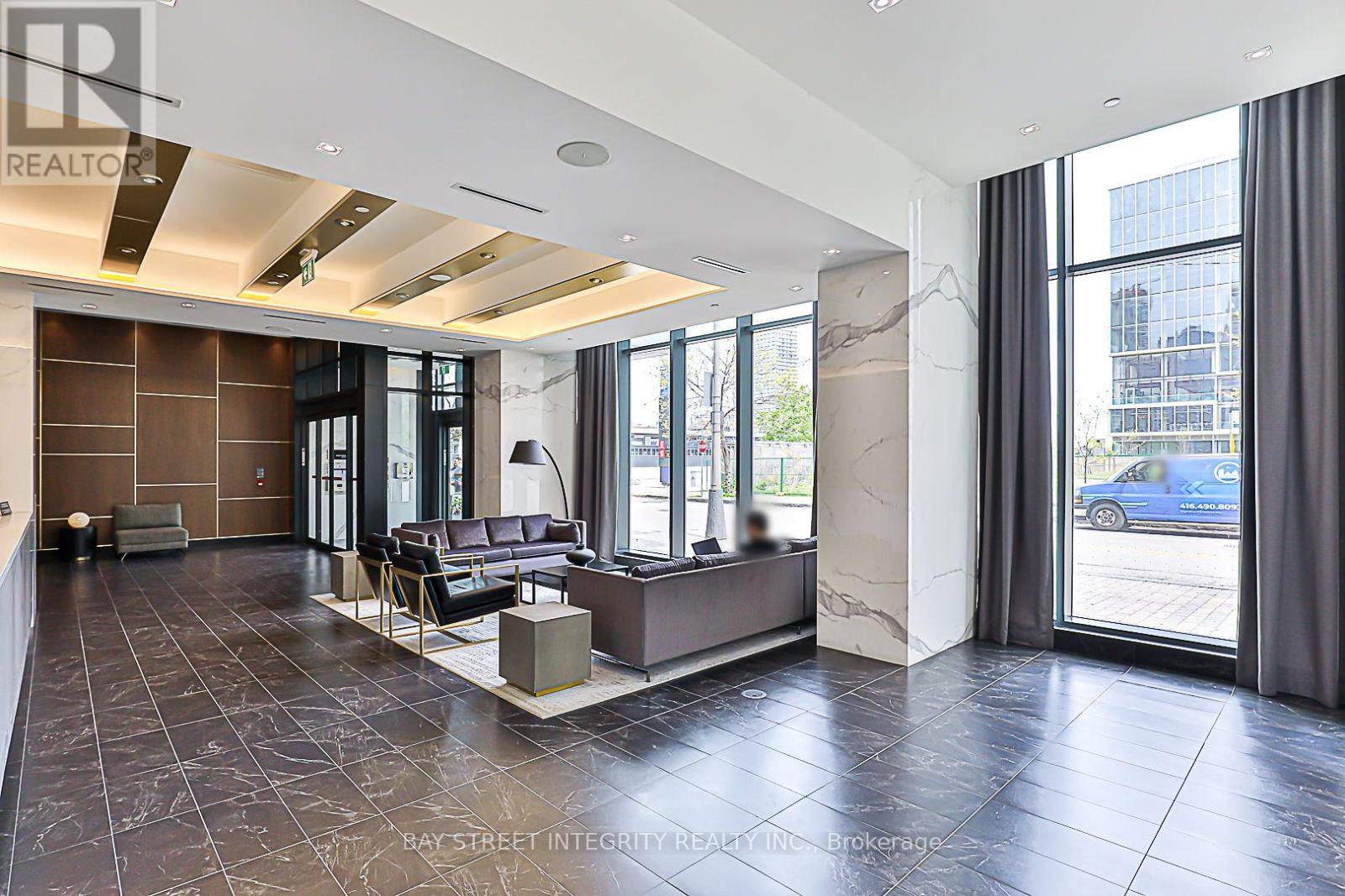 A spacious living room with a large window and a view of the street.