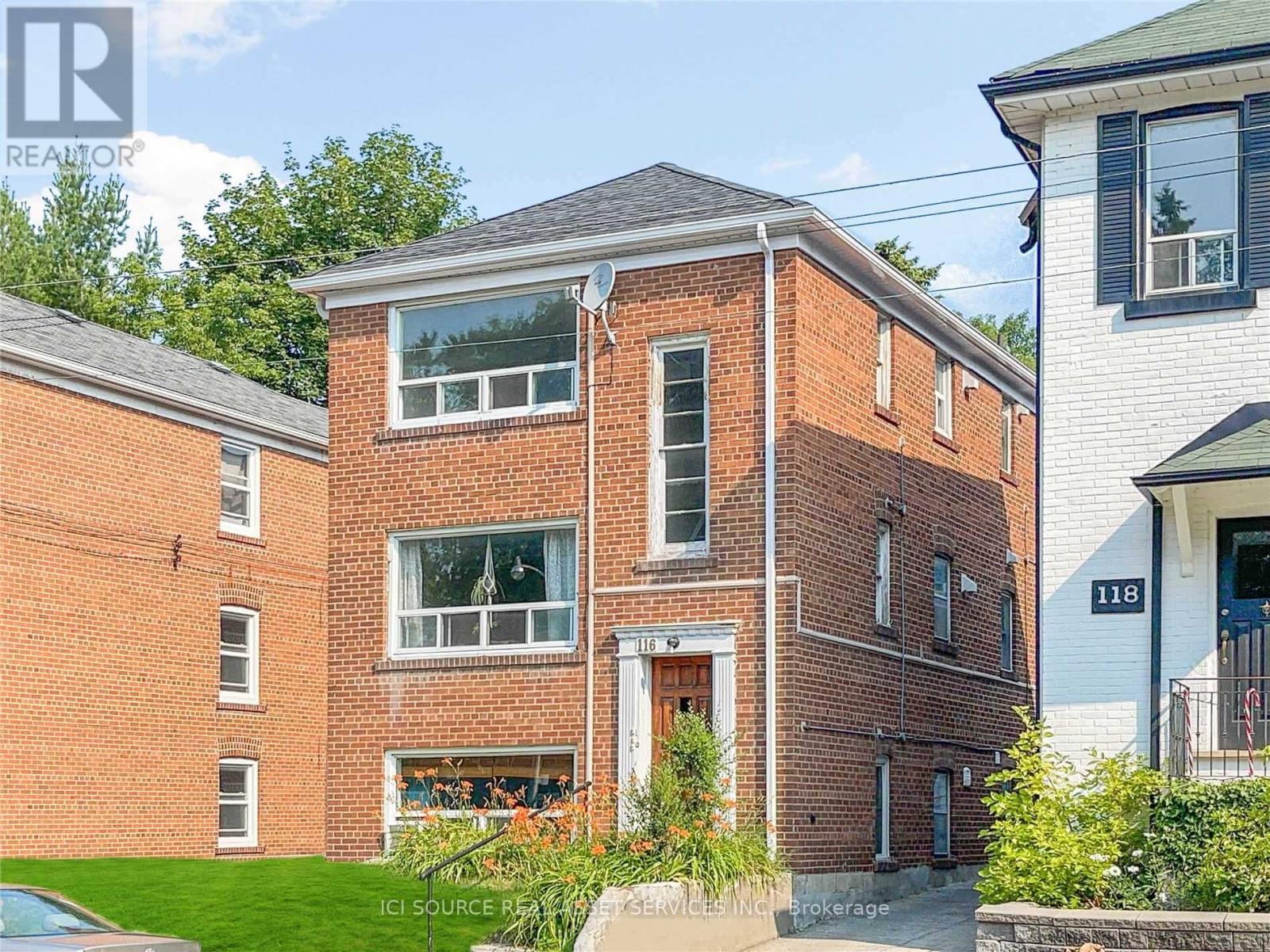 A red brick house with a white door and windows.