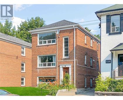 A red brick house with a white door and windows.