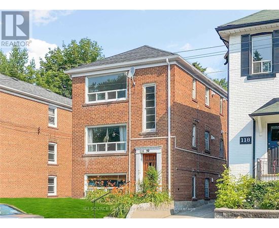 A red brick house with a white door and windows.