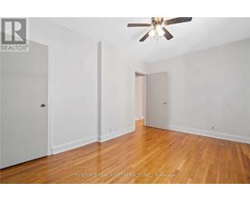 A room with a ceiling fan and wooden floors.