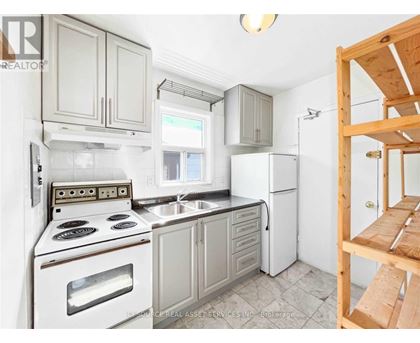 A kitchen with white appliances and wooden cabinets.