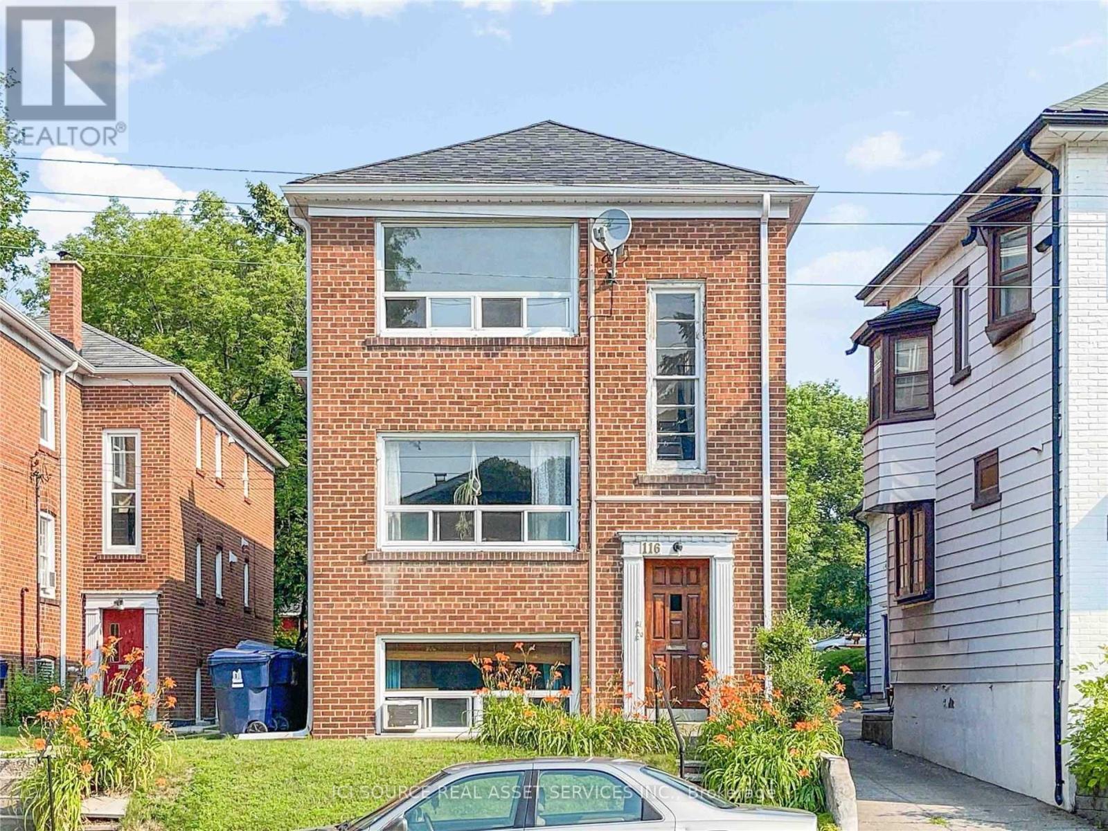 A brick house with a car parked in front of it.