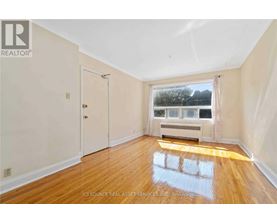 A room with wooden floors and a window overlooking a body of water.
